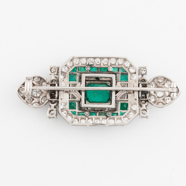 An 18K white gold Marchak art deco brooch set with step-cut emeralds.