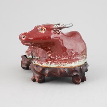 A sang-de-boeuf glazed Chinese porcelain figure of a water buffalo, around the year 1900.