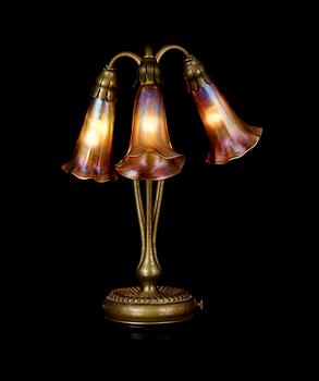 A Tiffany Studios 'Three Lily' lamp with a bronze base, New York circa 1910.