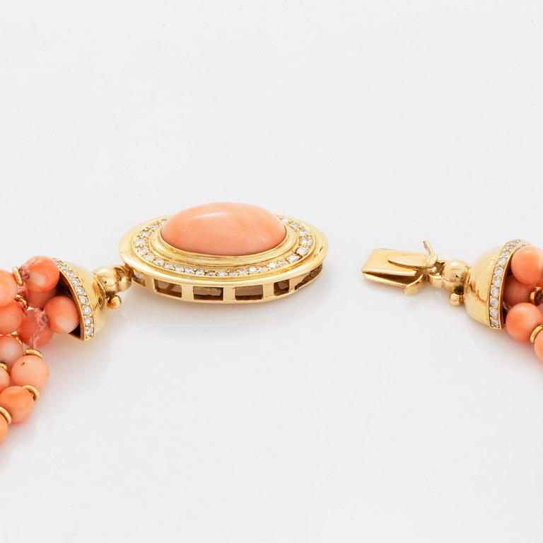 A four strand coral necklace with an 18K gold clasp set with coral and round brilliant-cut diamonds.