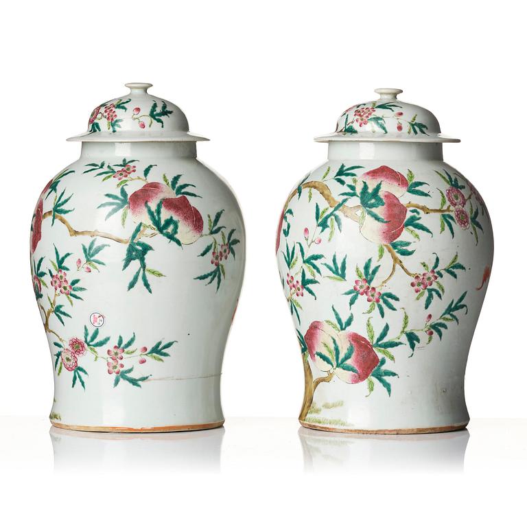 A pair of Chinese famille rose peach vases with covers, late Qing dynasty/circa 1900.