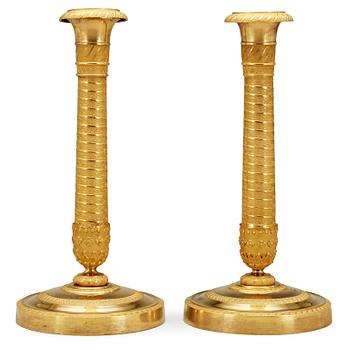 628. A pair of French Empire early 19th Century candlesticks.