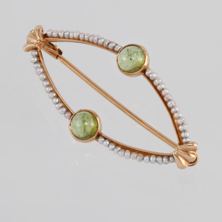 BROSCH, 18K guld med 2 cabochonlipade peridoter samt små odlade pärlor, Engelbert, Stockholm, 1956. Vikt 2,8 gram.
