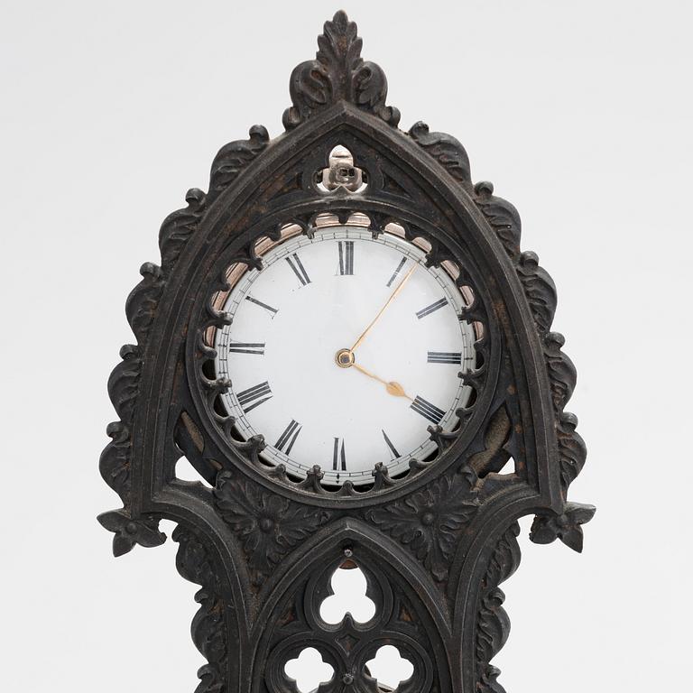 A neo-gothic cast iron pocket watch stand with a pocket watch. 19th century.