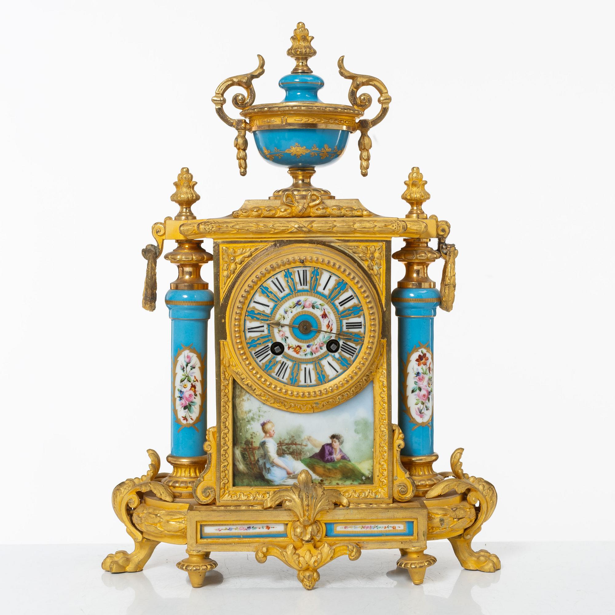 A French Louis XVI-style mantel clock and a pair of candelabra, late 19th Century.