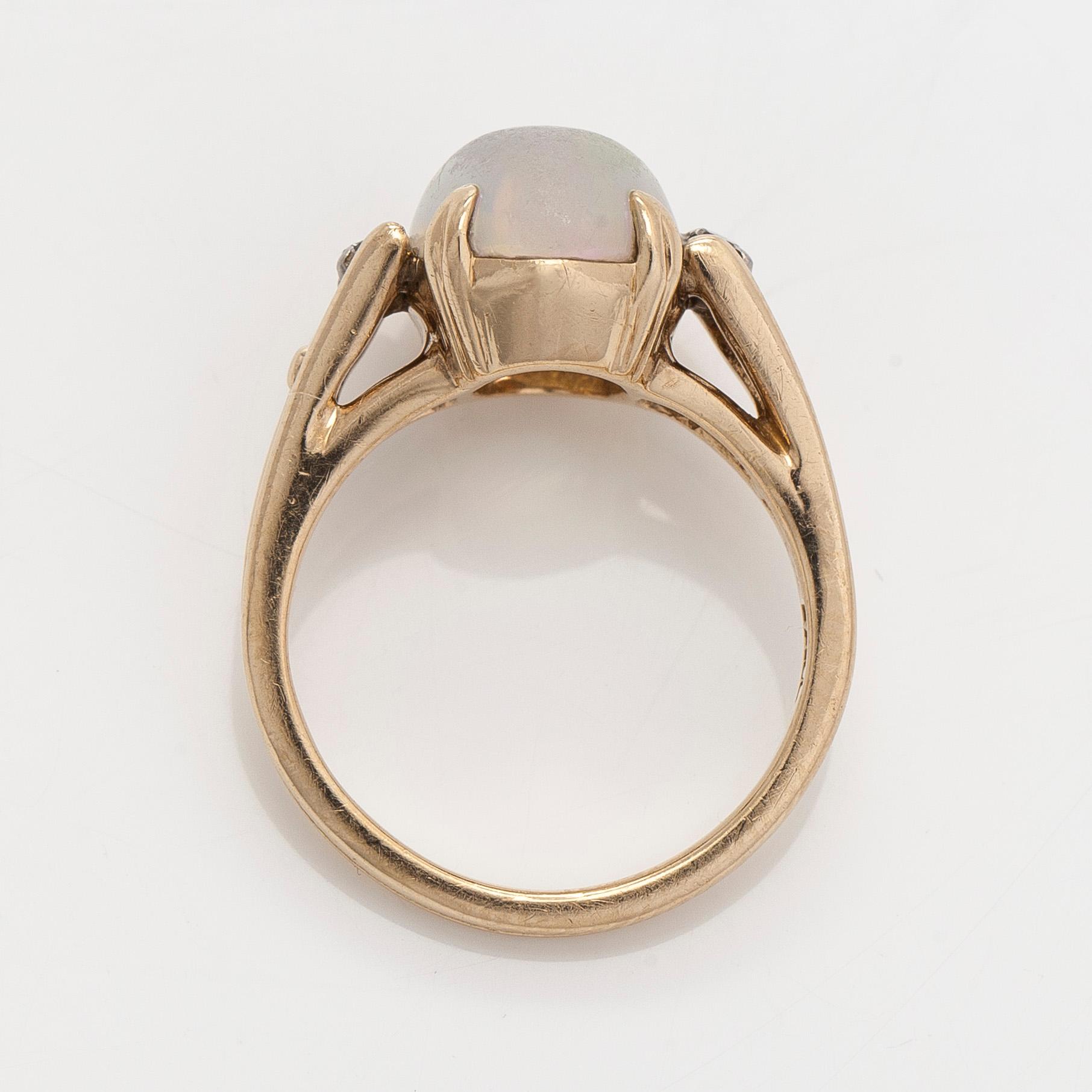 Ring in 14K gold with an oval opal and diamonds.