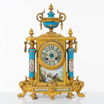A French Louis XVI-style mantel clock and a pair of candelabra, late 19th Century.
