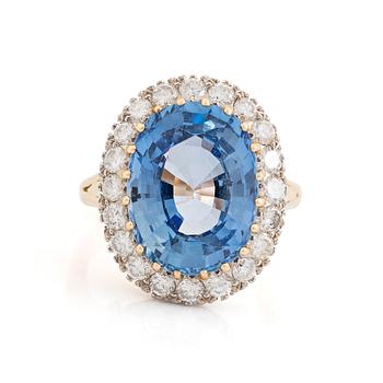 454. An 18K gold ring set with a faceted sapphire and round brilliant-cut diamonds.