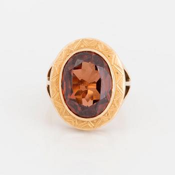 A ring with a faceted brown stone.