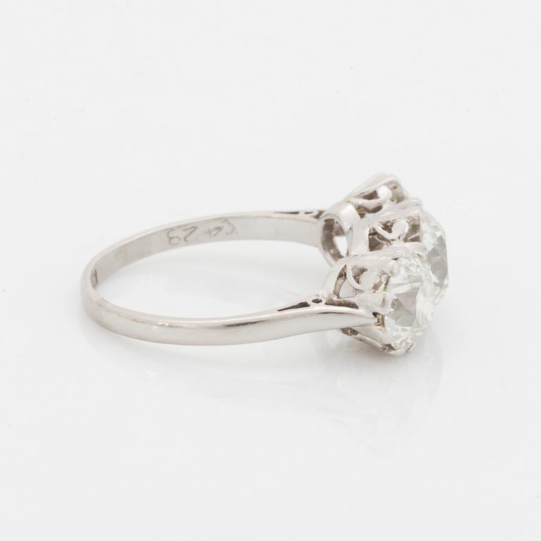 A platinum ring set with three old-cut diamonds.