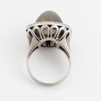 A cabochon cut grey moonstone and diamond ring.