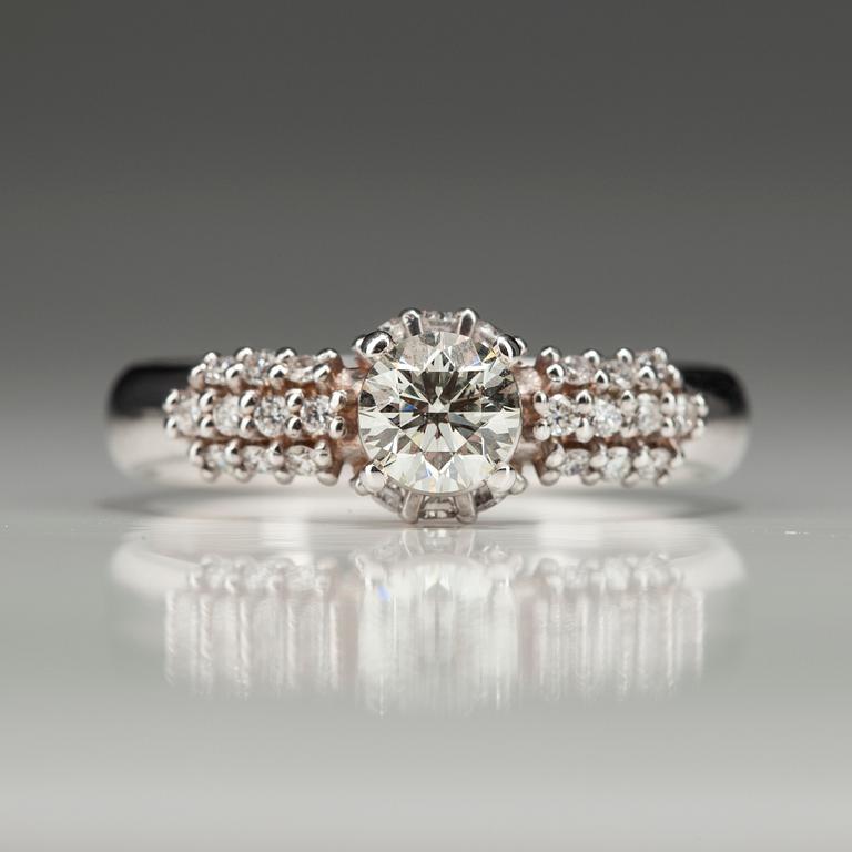 RING, vitguld 18K med diamanter. Mittstenen 0,52 ct L/SI1. 26 små diamanter tot 0,35 ct H/SI1. Intyg.
