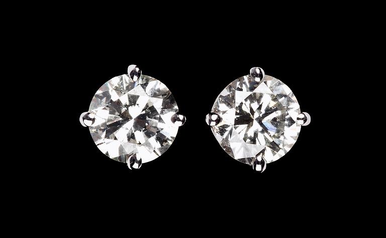 A pair of brilliant cut diamond studs, 1.51 cts/1.47 cts.