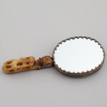 A silver gilt copper mirror with nefrite handle in the shape of a belt hook.