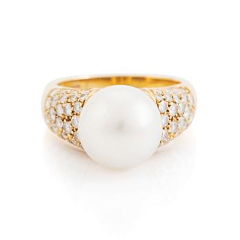 An 18K gold ring set with a cultured South Sea pearl and round brilliant-cut diamonds.