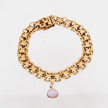 An 18K gold x-link bracelet with cabochon cut amethyst.