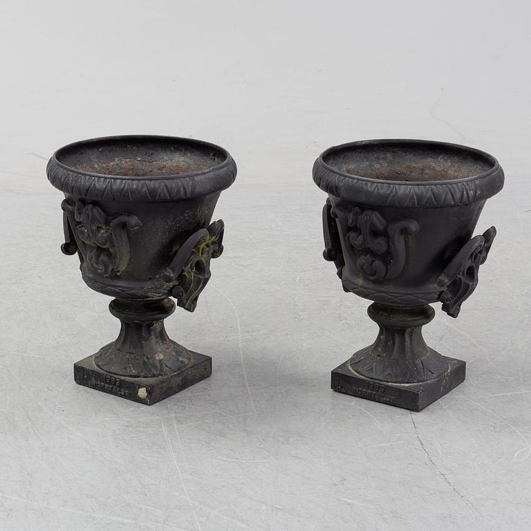 A pair of cast iron garden urns, Norrtälje dated 1989.