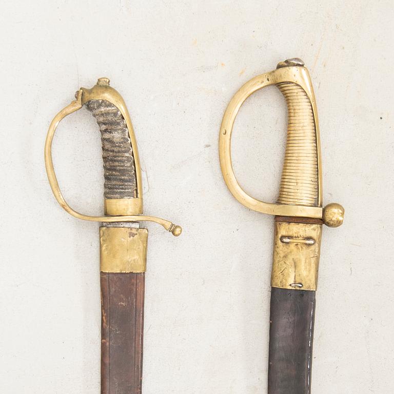 To cutlasses, 19th century, with scabbards.