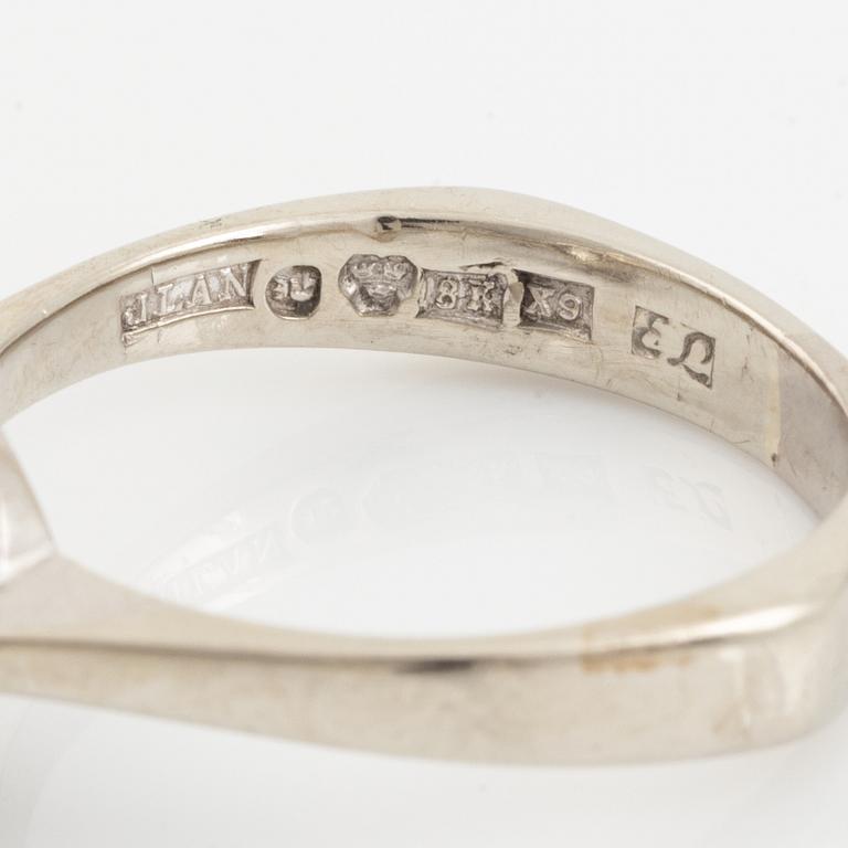 An 18K white gold ring set with a round brilliant-cut diamond.