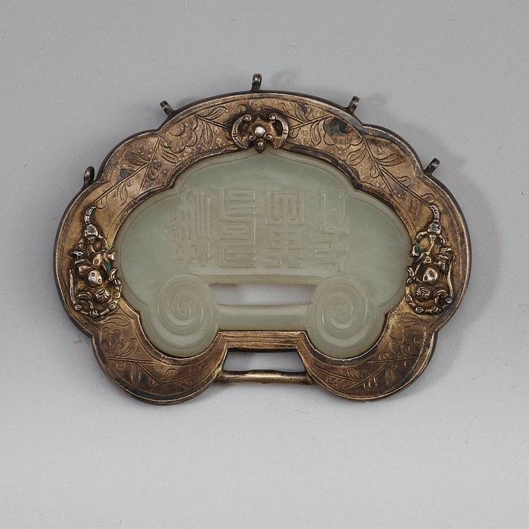 A carved nephrite clasp with silverplated mounting, late Qing dynasty (1664-1912).