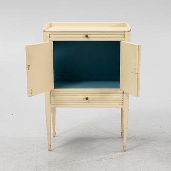 A Gustavian style painted bedside cabinet from around the year 1900.