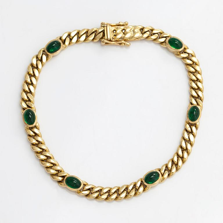 An 18K gold curb link bracelet with cabochon-cut green garnets.