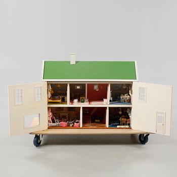 A 1980s doll house with various dolls and furniture.