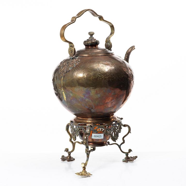 A German Rococo repoussé copper teapot on rechaud, mid 18th century.