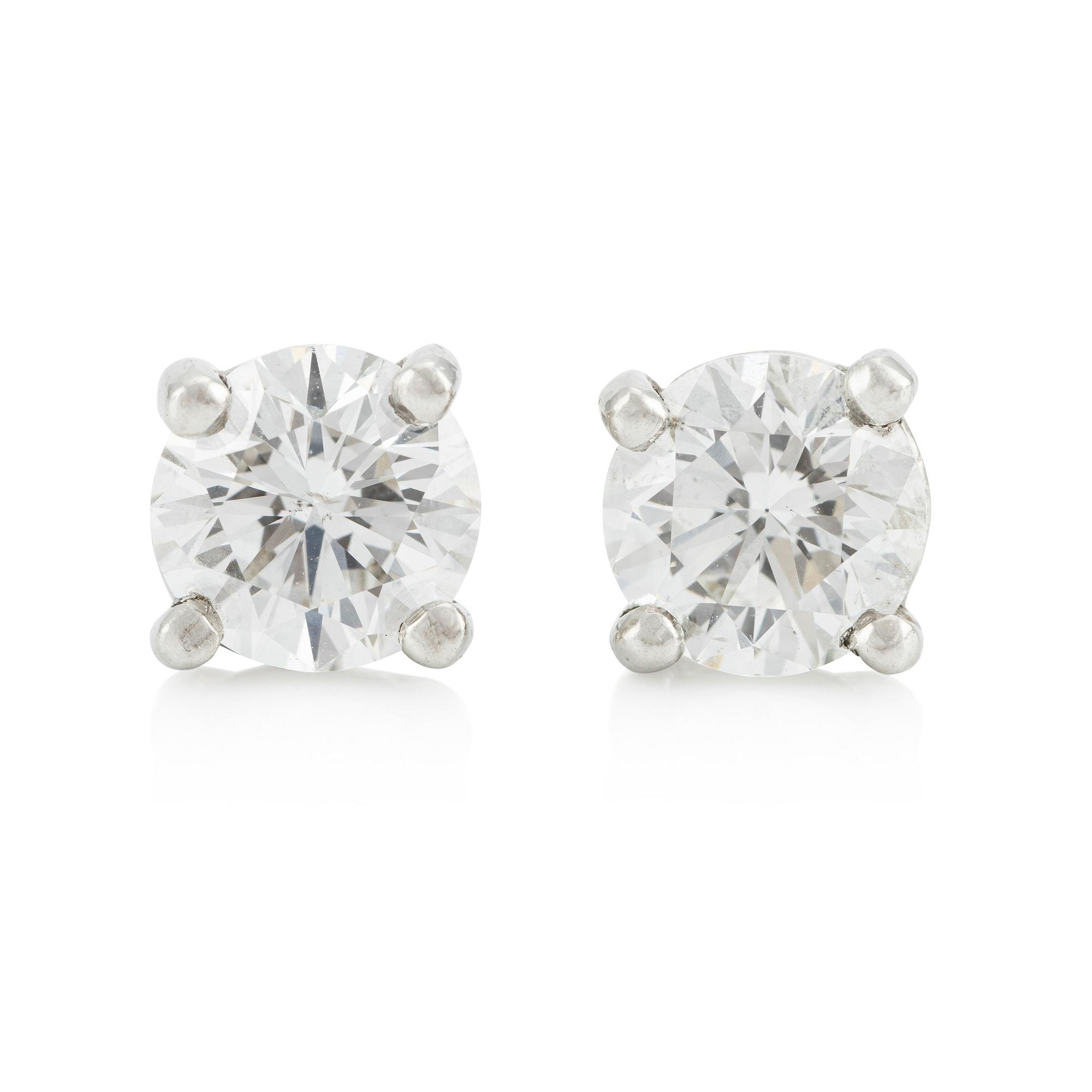 A pair of platinum earrings with round brilliant-cut diamonds.