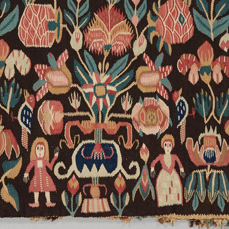 A CARRIAGE CUSHION. Tapestry weave. "Urnor och par". 48,5 x 101,5 cm. Southern Scania, Sweden, 19th century.