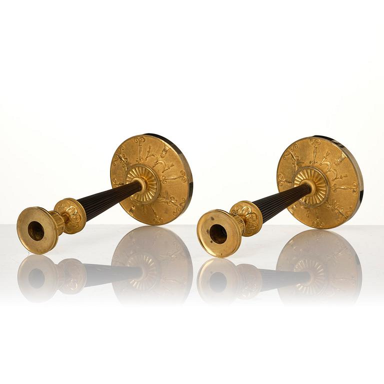 A pair of Empire ormolu and patinated bronze candlesticks.
