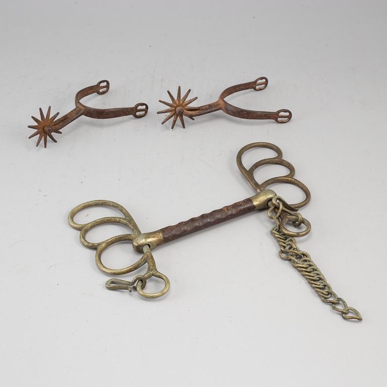 A pair of spurs and a bit, cast iron, 19th century.