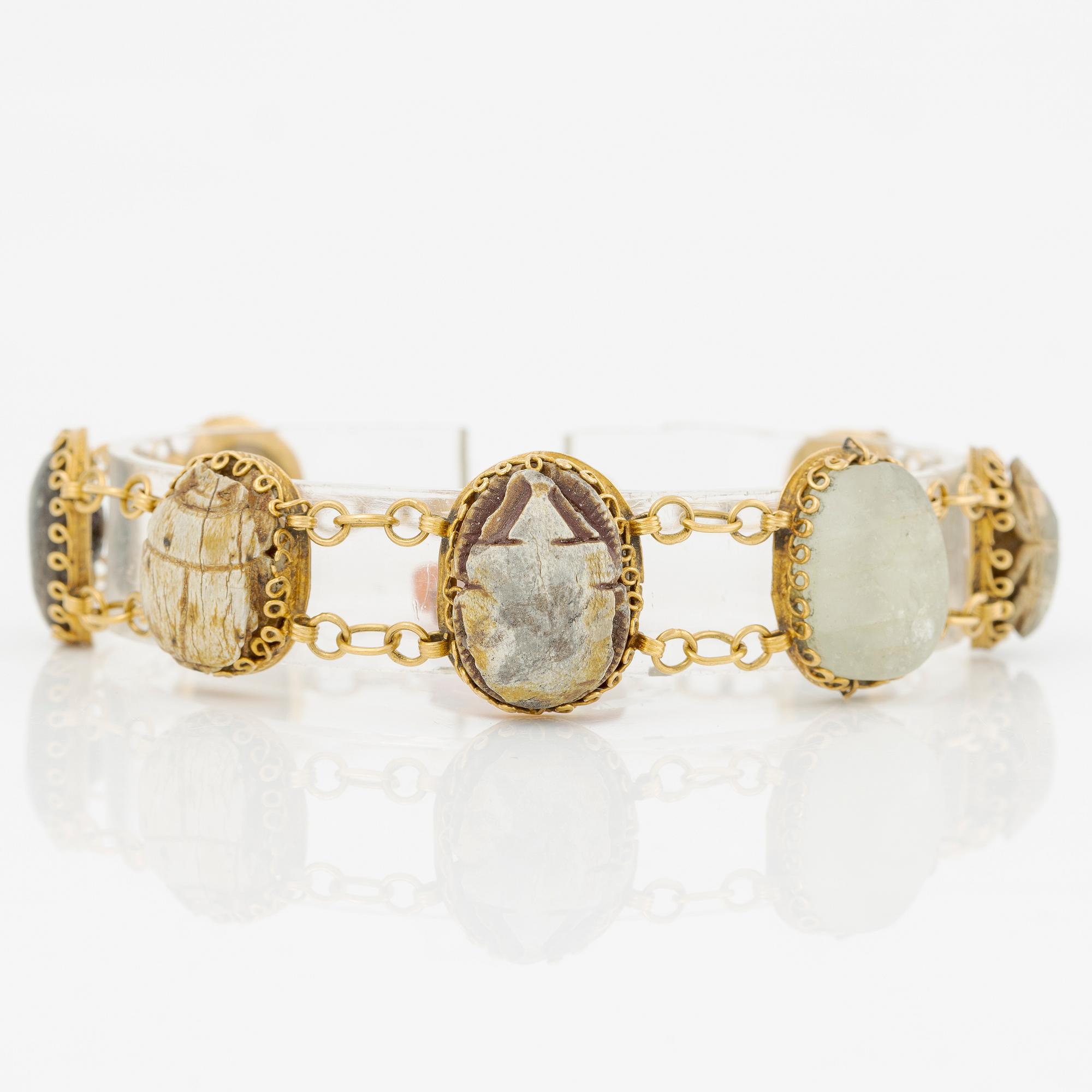 Bracelet in 14K gold with various minerals and scarab-shaped charms.