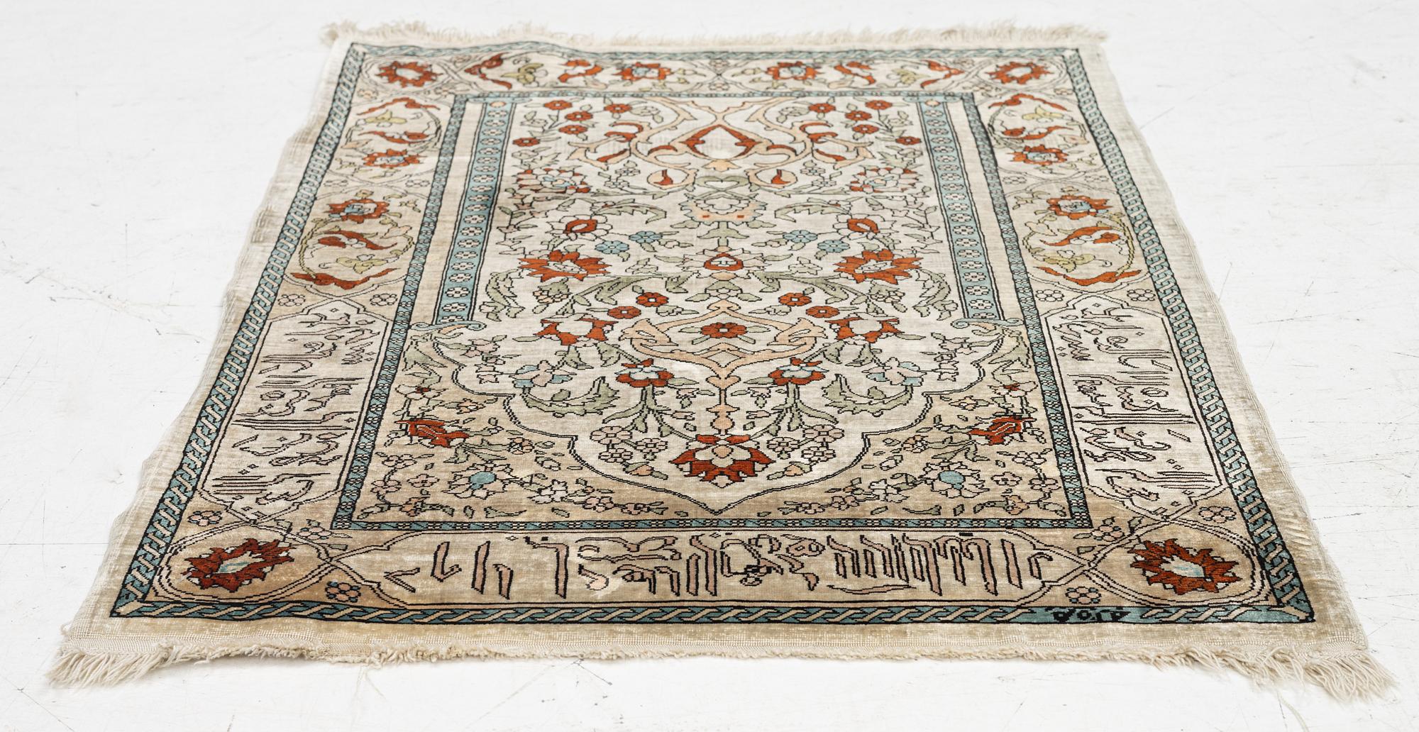 A Hereke silk rug, c. 73 x 52 cm.