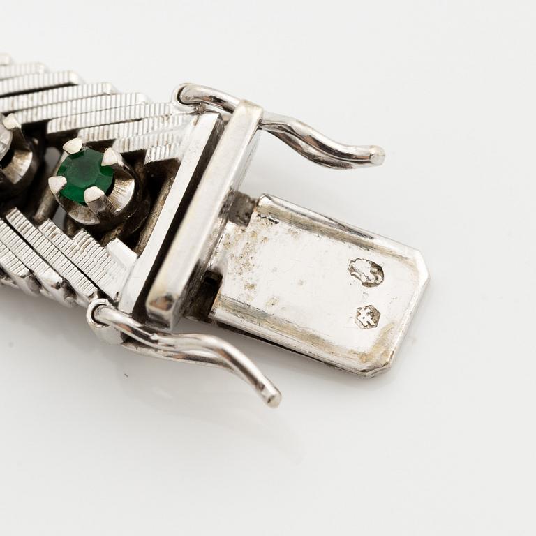 Bracelet 18K gold with round brilliant-cut diamonds and green stones, likely emeralds.