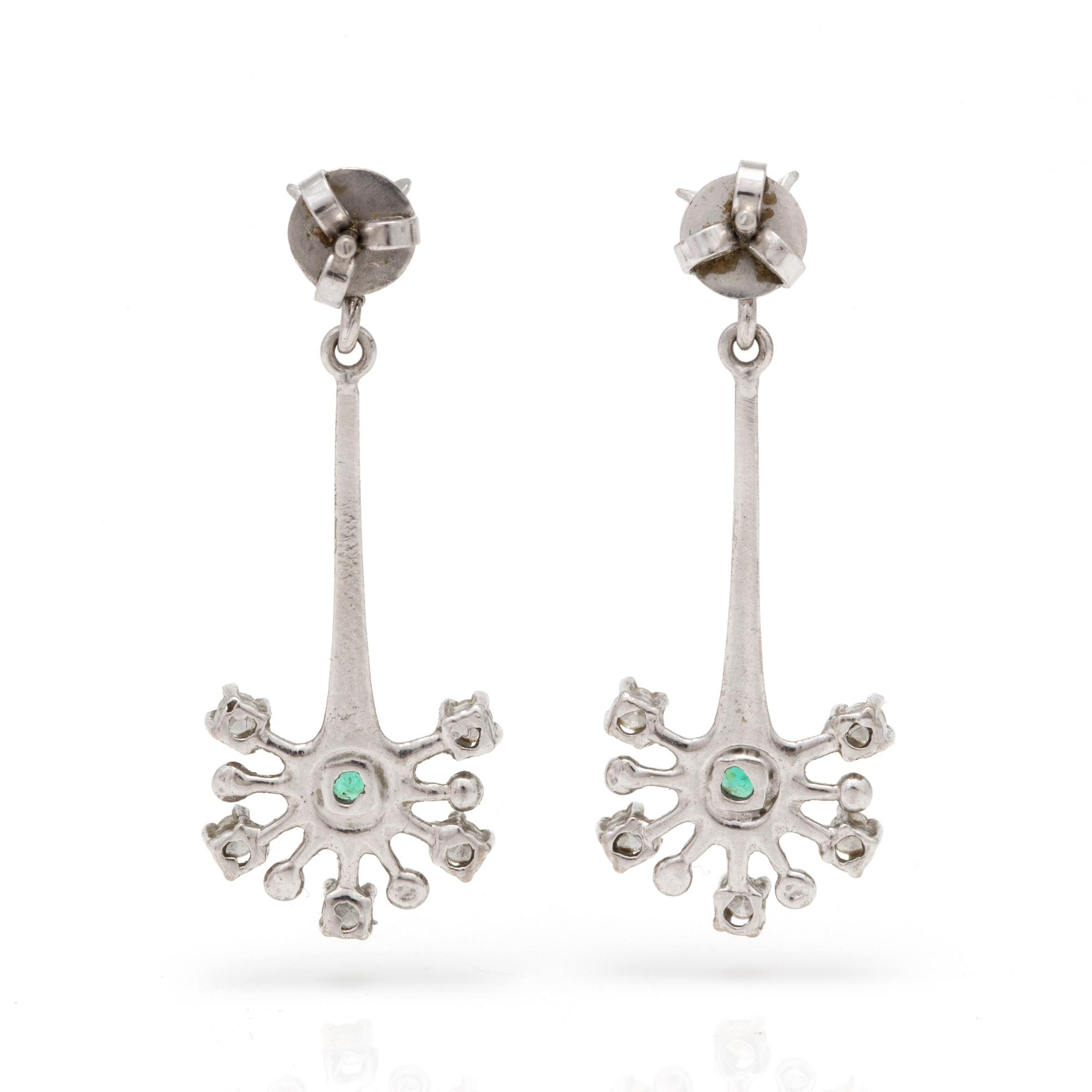 A pair of earrings with fasettslipade smaragder och diamanter.