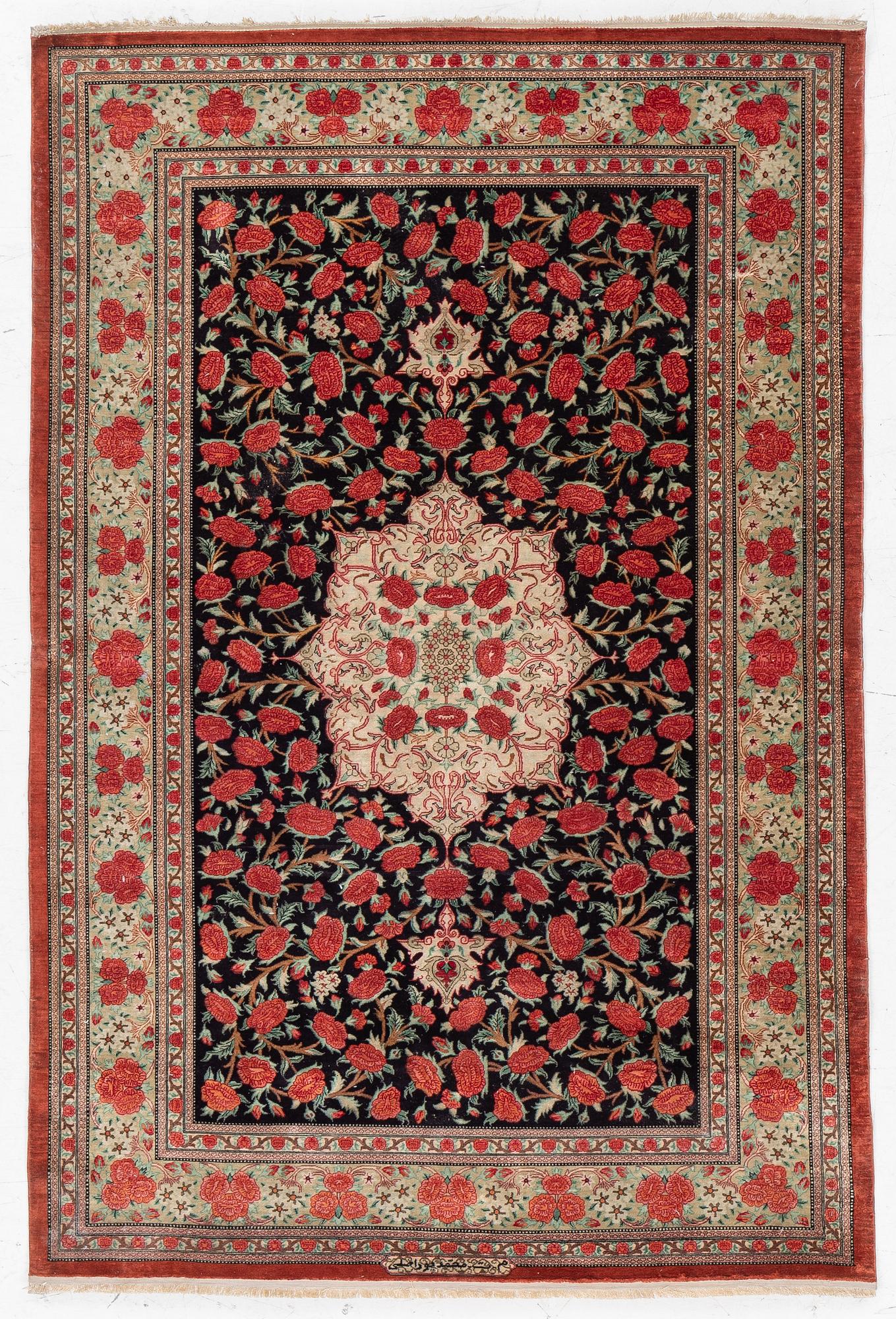 A signed silk Qum rug. c. 154 x 103 cm.