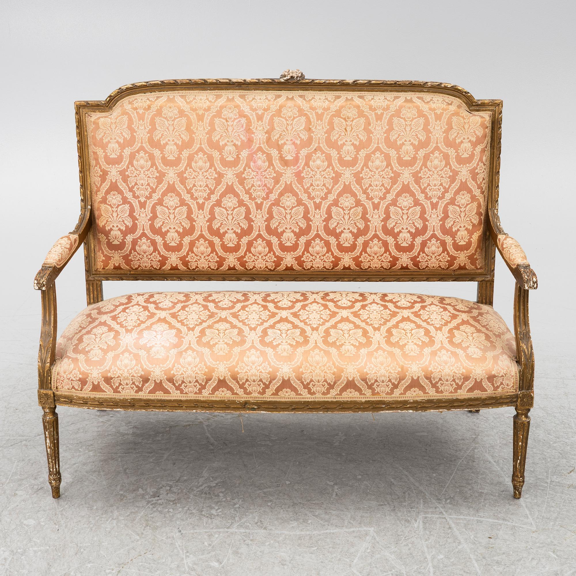 A pair of Louis XVI-style armchairs and a sofa, 20th century.