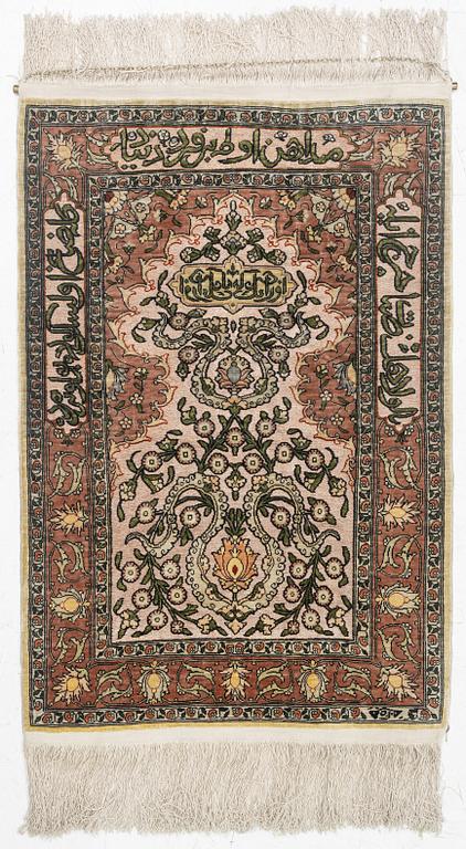 A silk Hereke rug, c. 77 x 53 cm.
