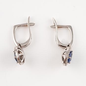 A pair of 14K gold earrings with faceted sapphires and round brilliant-cut diamonds.