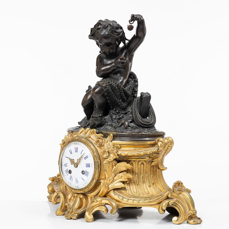 A Rococo style mantle clock and pair of candelabra, France, late 19th Century.