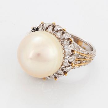 An 18K gold ring set with a cultured pearl and round brilliant-cut diamonds.