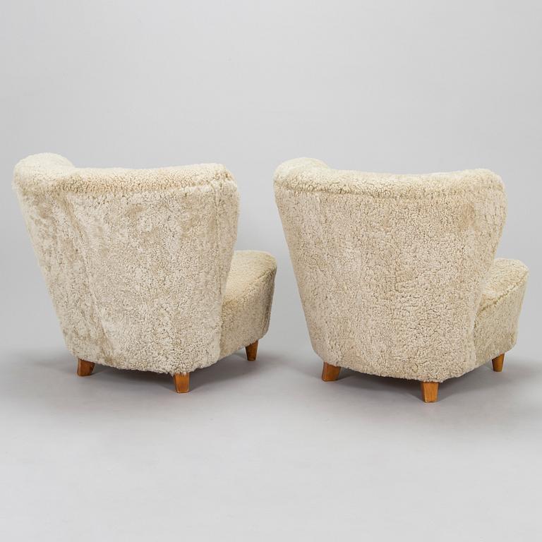A pair of mid-20th century armchairs in sheepskin.