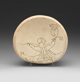 A potted white glazed pillow with incised decor of a boy, presumably Liao or Song Dynasty (907-1279).