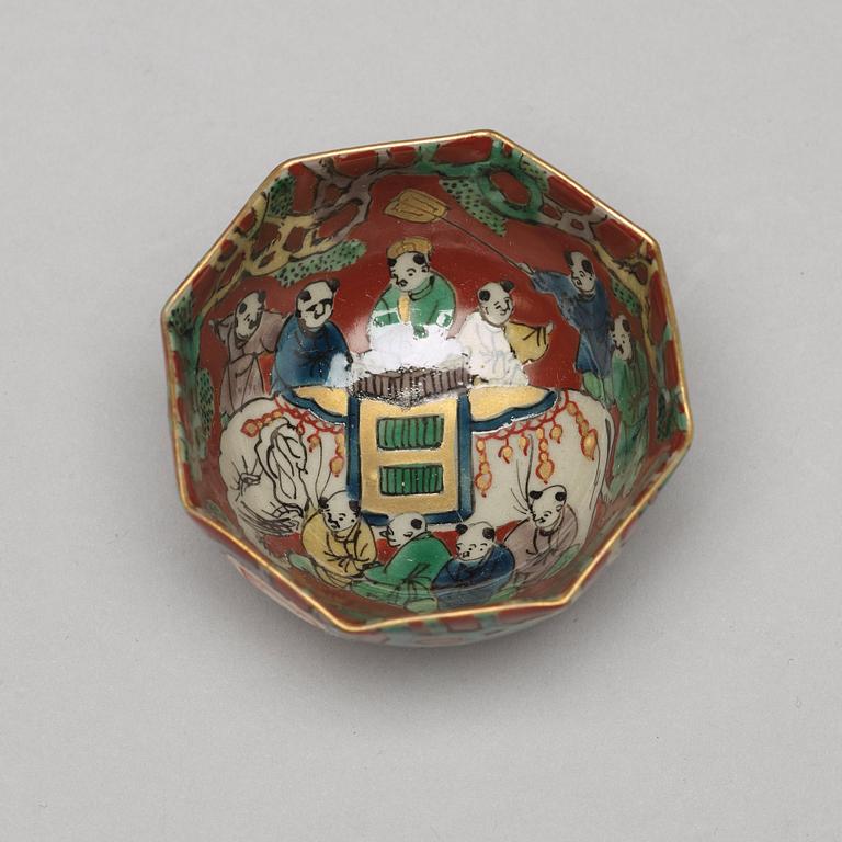 A set of two Japanese figures and a set of six cups in a wooden box, early 20th Century.