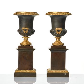 A pair of French Louis Philippe gilt and patinated bronze urns, first part 19th century.