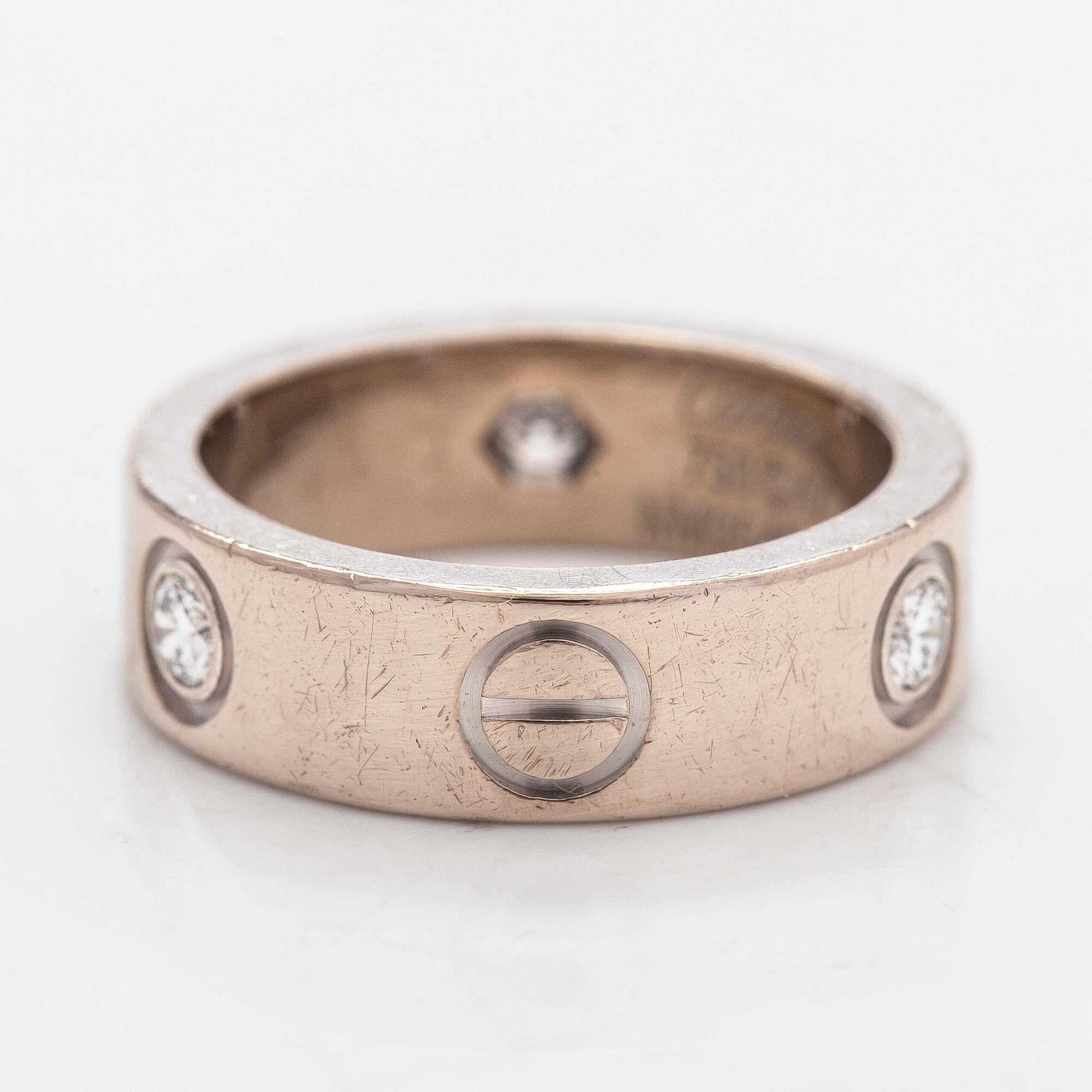 Cartier, an 18K white gold 'Love' ring with three brilliant-cut diamonds.