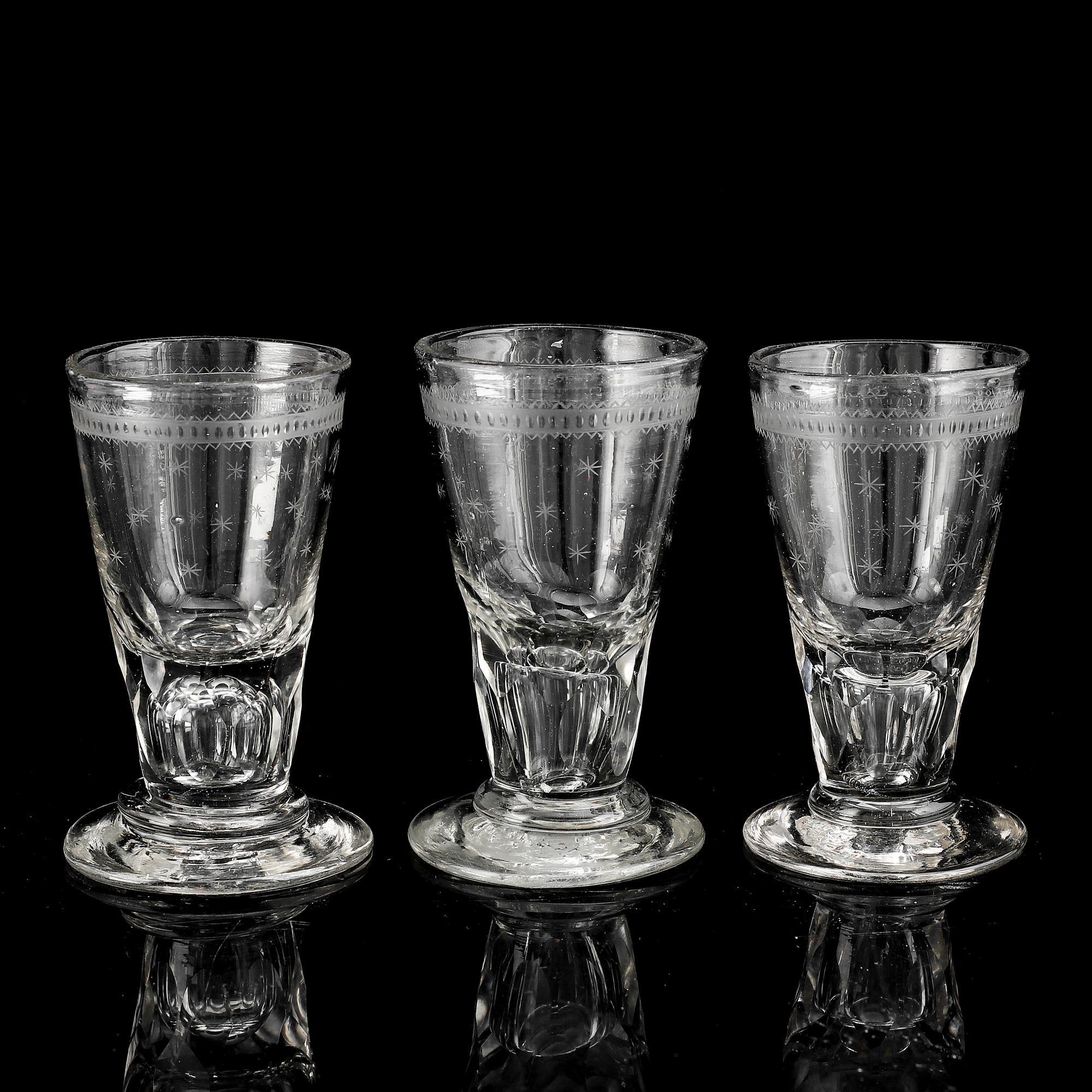 A glass bottle and three vodka glasses, 19th Century.