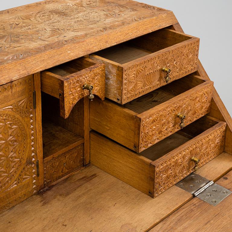 A carved oak secretaire, 19th Century.