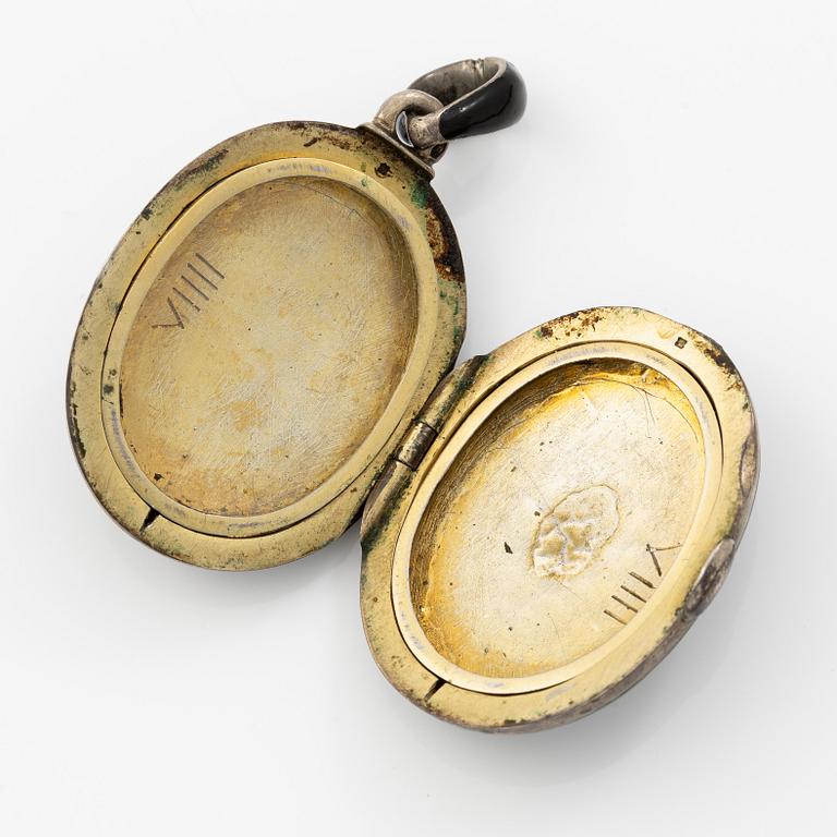 Samling smycken silver med svarta fasettslipade stenar, tre broscher, hattnål, medaljong och armband.